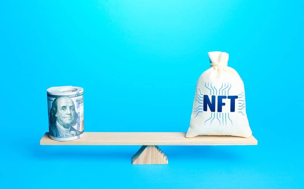 bag with NFT logo balanced on scale with roll of $100 bills